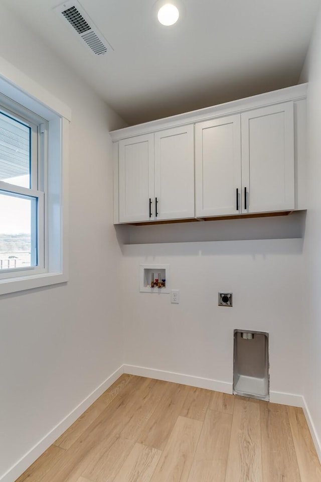 laundry room with electric dryer hookup, light hardwood / wood-style floors, cabinets, and hookup for a washing machine