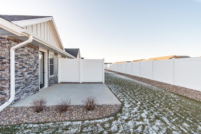 yard layered in snow with a patio