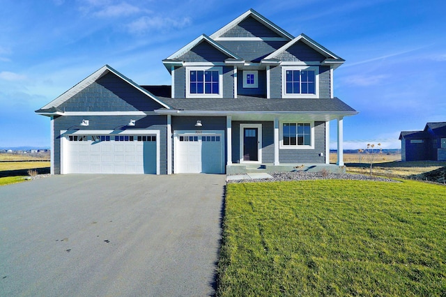 view of front of house with a garage, a porch, and a front lawn