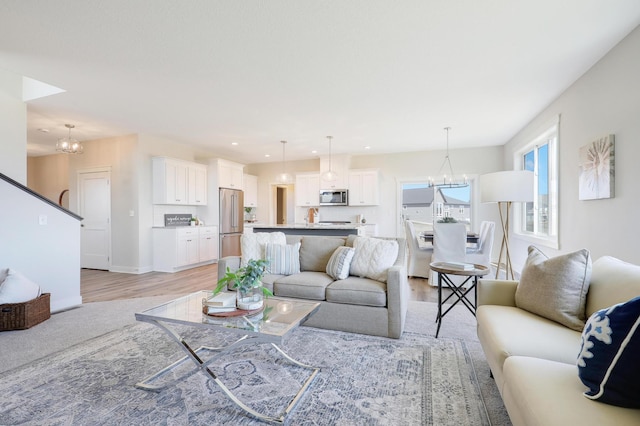 living room with light hardwood / wood-style floors and a notable chandelier