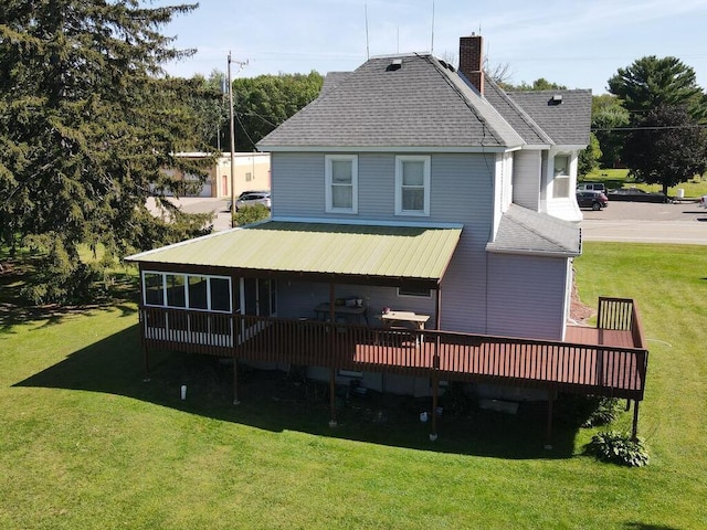 rear view of property with a yard and a wooden deck