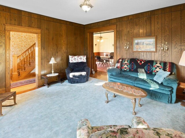 carpeted living room with wooden walls