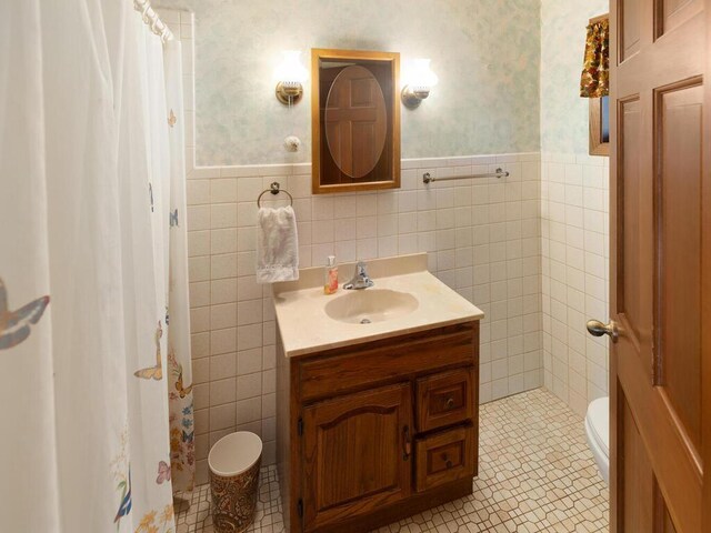 bathroom featuring vanity, tile patterned floors, toilet, and tile walls