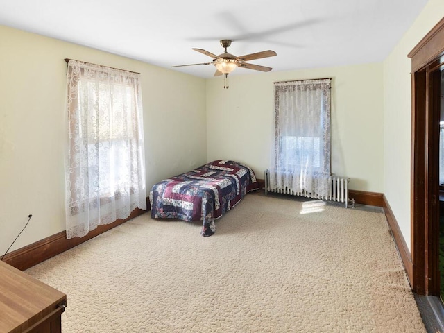 carpeted bedroom featuring ceiling fan and radiator heating unit