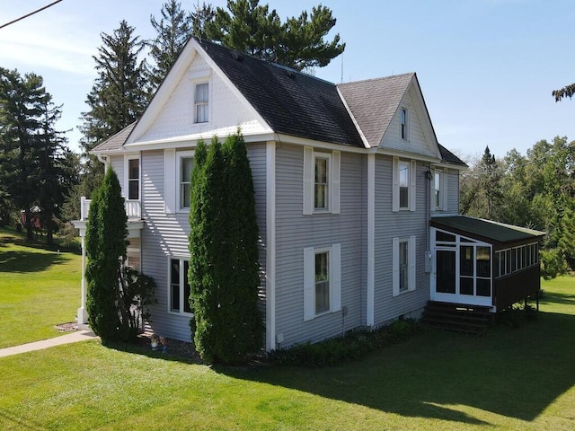 view of side of property featuring a yard and a sunroom