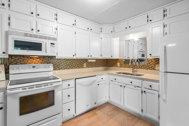 kitchen with light hardwood / wood-style flooring, white appliances, white cabinetry, and sink