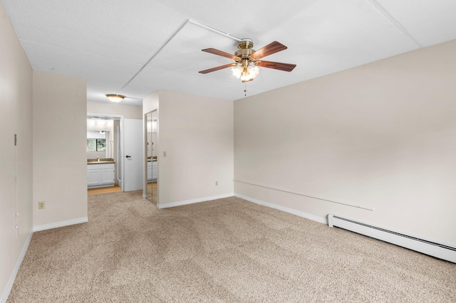 unfurnished room with light carpet, baseboard heating, and ceiling fan