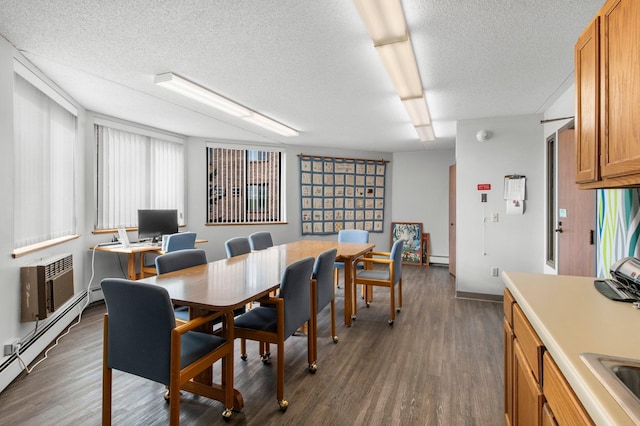 dining area with a textured ceiling, dark wood-type flooring, baseboard heating, and an AC wall unit