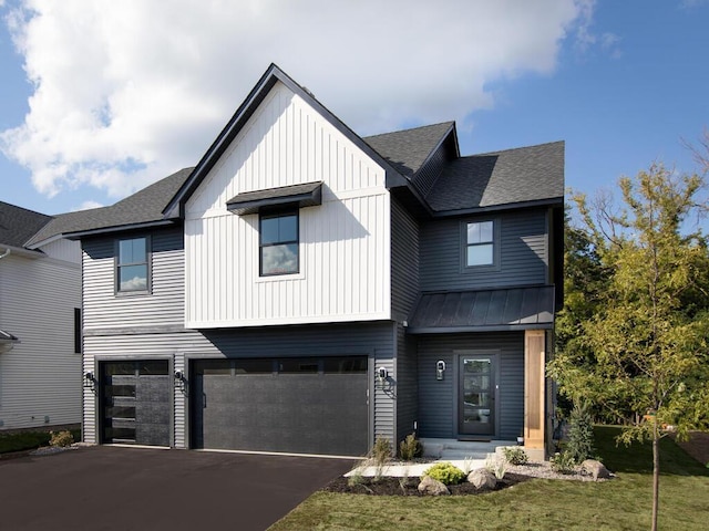 modern farmhouse with a front yard and a garage