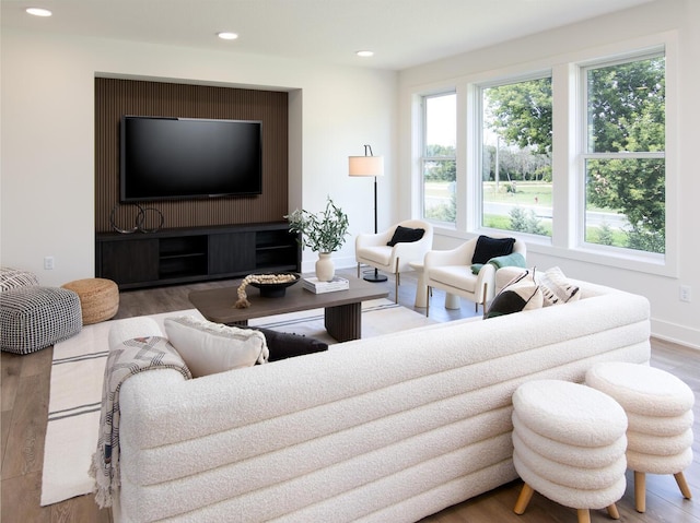 living area featuring recessed lighting, plenty of natural light, baseboards, and wood finished floors