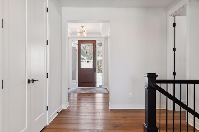 entrance foyer featuring dark hardwood / wood-style floors and a notable chandelier