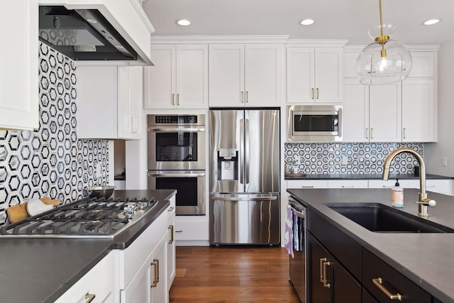 kitchen featuring custom range hood, stainless steel appliances, dark hardwood / wood-style flooring, sink, and pendant lighting