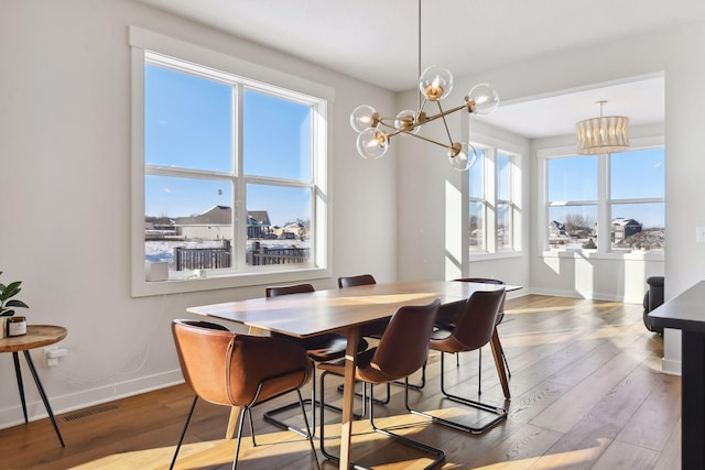 dining space featuring hardwood / wood-style floors and a chandelier