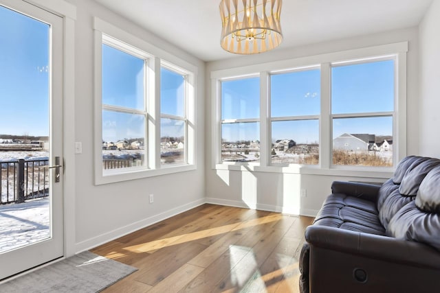 living room featuring hardwood / wood-style floors, a wealth of natural light, and a notable chandelier