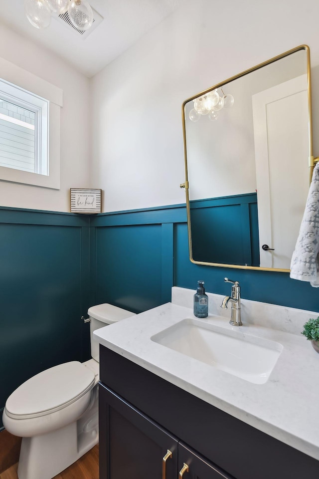 bathroom with vanity, toilet, and hardwood / wood-style flooring