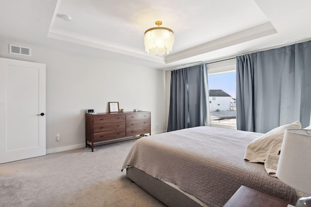 carpeted bedroom with a tray ceiling