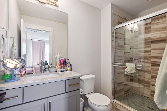 bathroom with walk in shower, toilet, a textured ceiling, and vanity