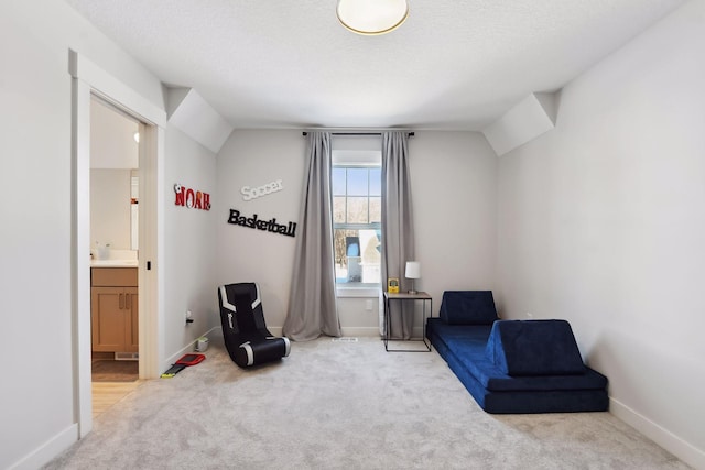 sitting room featuring light colored carpet, a textured ceiling, and vaulted ceiling