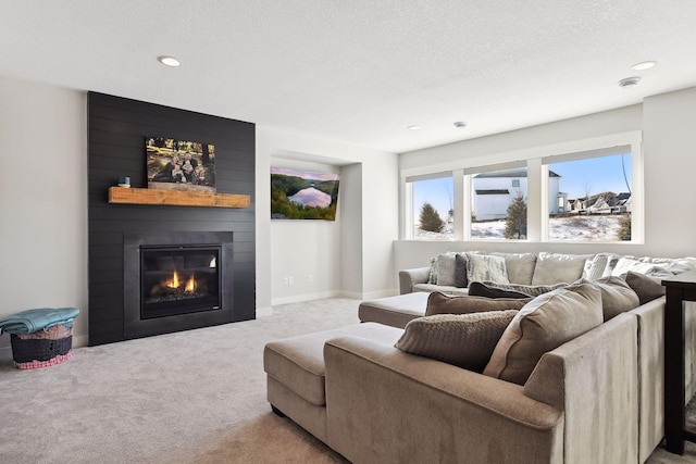 living room featuring a textured ceiling, carpet, and a fireplace