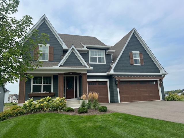 craftsman house featuring a porch, a front yard, and a garage