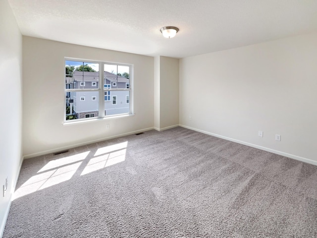 carpeted spare room featuring a textured ceiling