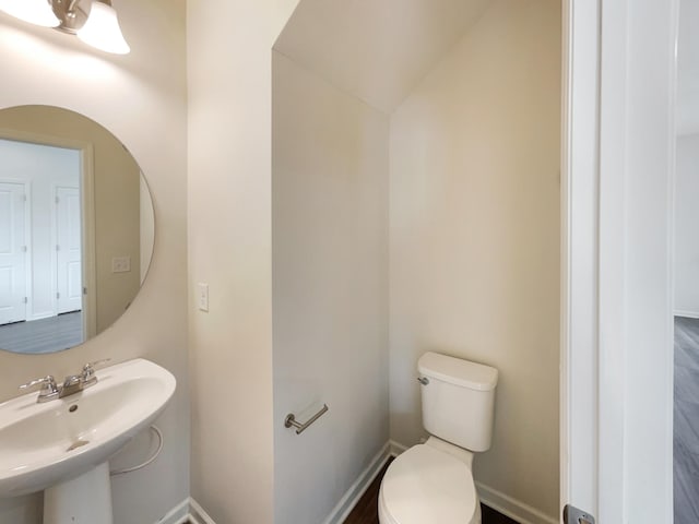 bathroom with sink, lofted ceiling, and toilet