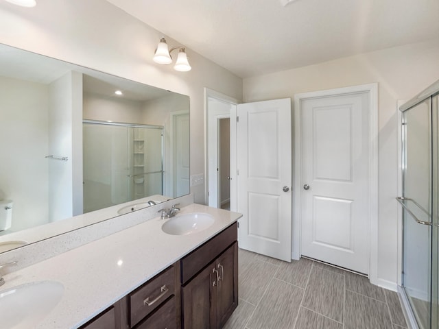 bathroom featuring vanity and a shower with door