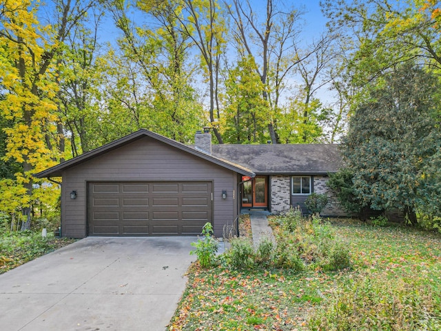 view of front of home featuring a garage, concrete driveway, brick siding, and a chimney