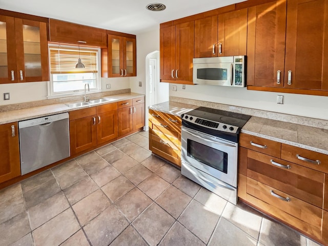 kitchen featuring appliances with stainless steel finishes, light tile patterned flooring, and sink