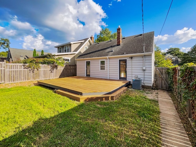 back of property with a wooden deck, a yard, and central air condition unit