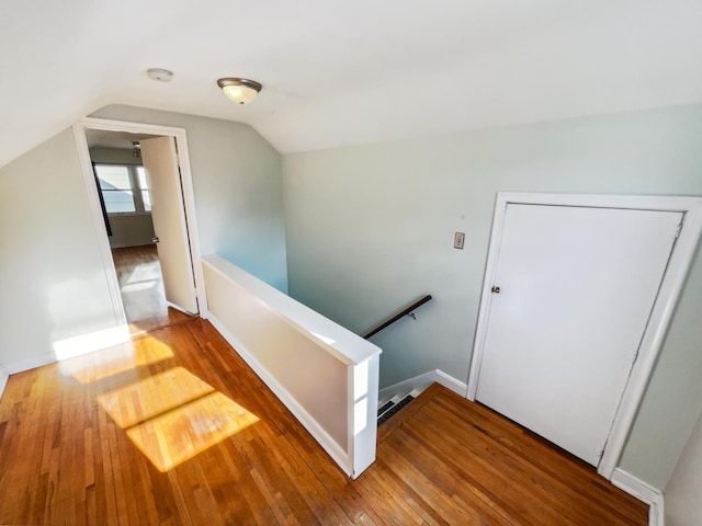 stairway featuring wood-type flooring and lofted ceiling