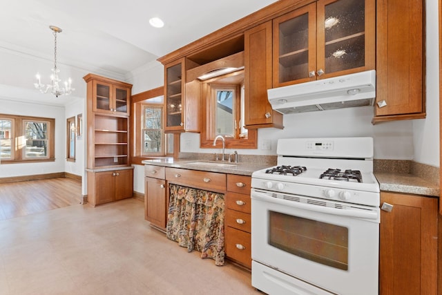 kitchen featuring sink, crown molding, an inviting chandelier, white range with gas cooktop, and hanging light fixtures