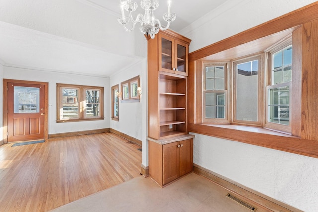 interior space with a notable chandelier and ornamental molding