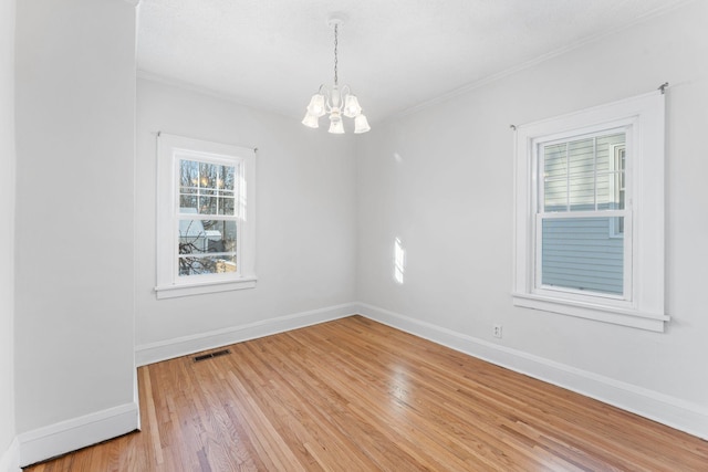 unfurnished room with wood-type flooring and a notable chandelier