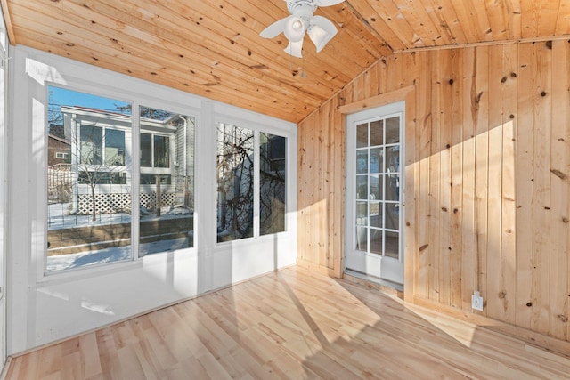 interior space featuring lofted ceiling, light hardwood / wood-style floors, wood walls, ceiling fan, and wooden ceiling