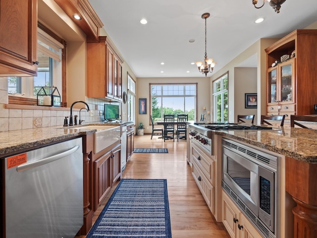 4424 Donway Dr NE, Alexandria, MN 56308 - kitchen featuring appliances with stainless steel finishes, a chandelier, backsplash, recessed lighting, and glass insert cabinets
