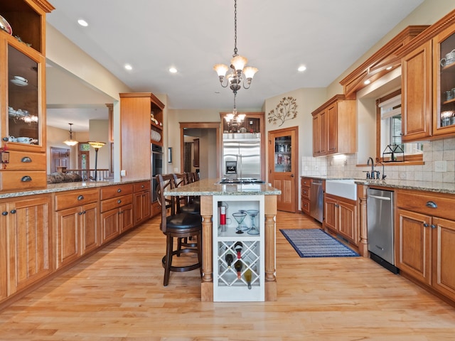 4424 Donway Dr NE, Alexandria, MN 56308 - kitchen featuring appliances with stainless steel finishes, open shelves, a chandelier, a kitchen breakfast bar, and tasteful backsplash