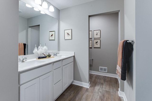 bathroom with vanity, hardwood / wood-style flooring, and a textured ceiling