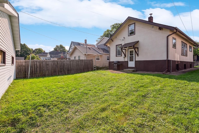 rear view of house featuring a yard