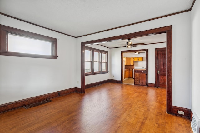 unfurnished living room with crown molding, a textured ceiling, wood-type flooring, and ceiling fan