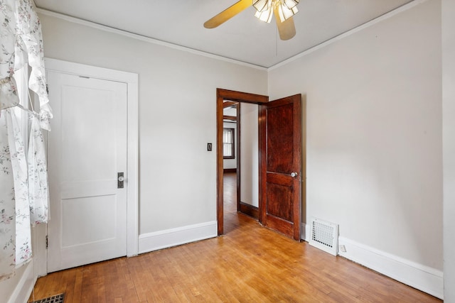 unfurnished bedroom with light wood-type flooring, ceiling fan, and crown molding