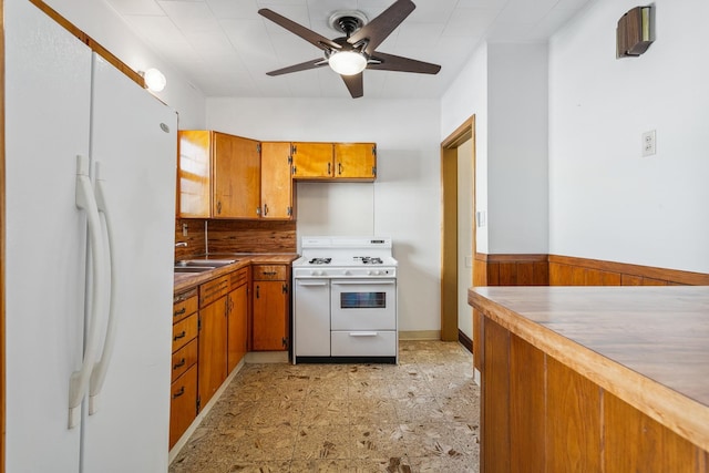 kitchen featuring ceiling fan, white appliances, and wooden walls