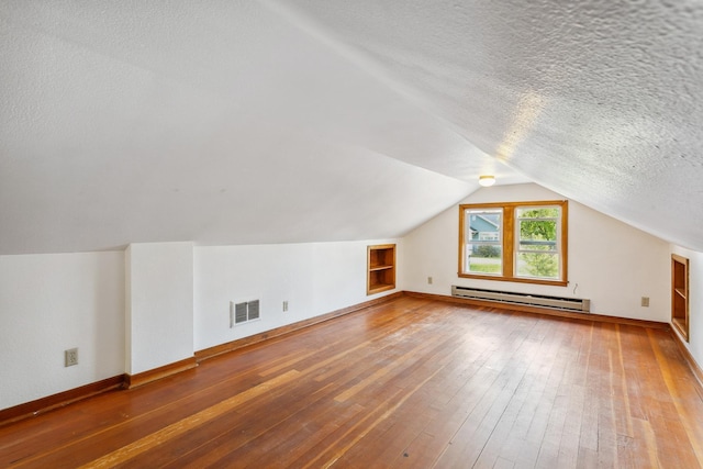 bonus room with lofted ceiling, a baseboard radiator, hardwood / wood-style flooring, and a textured ceiling