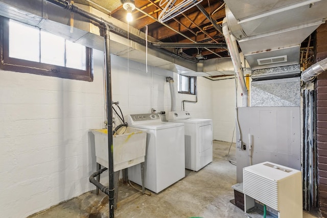 clothes washing area with washer and clothes dryer and sink