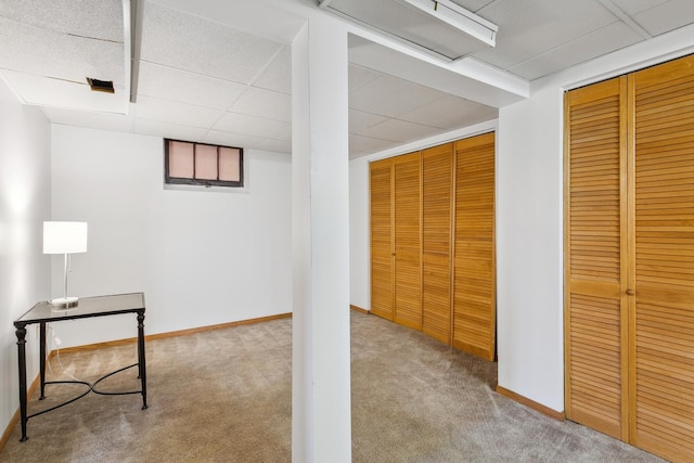 basement with light carpet and a drop ceiling