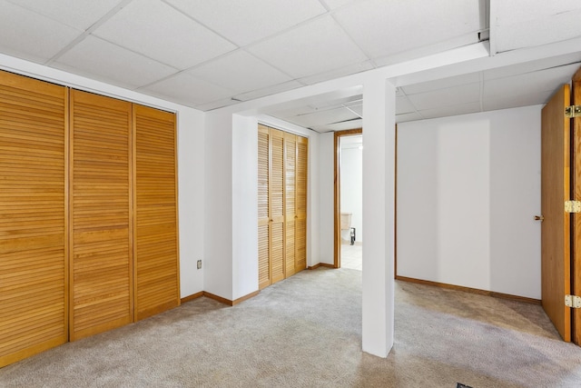 unfurnished bedroom featuring light carpet and a drop ceiling