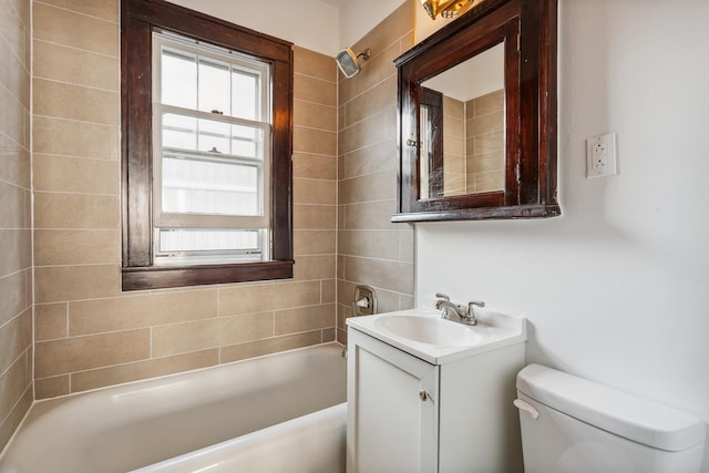 full bathroom featuring vanity, tiled shower / bath combo, and toilet