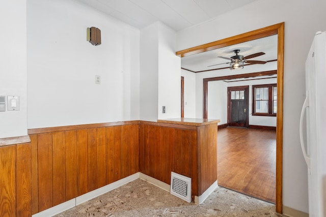 unfurnished room featuring ornamental molding, ceiling fan, and wood walls