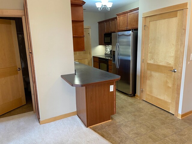 kitchen featuring kitchen peninsula, stainless steel fridge with ice dispenser, backsplash, and a chandelier