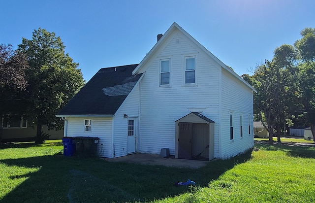 rear view of house featuring a lawn